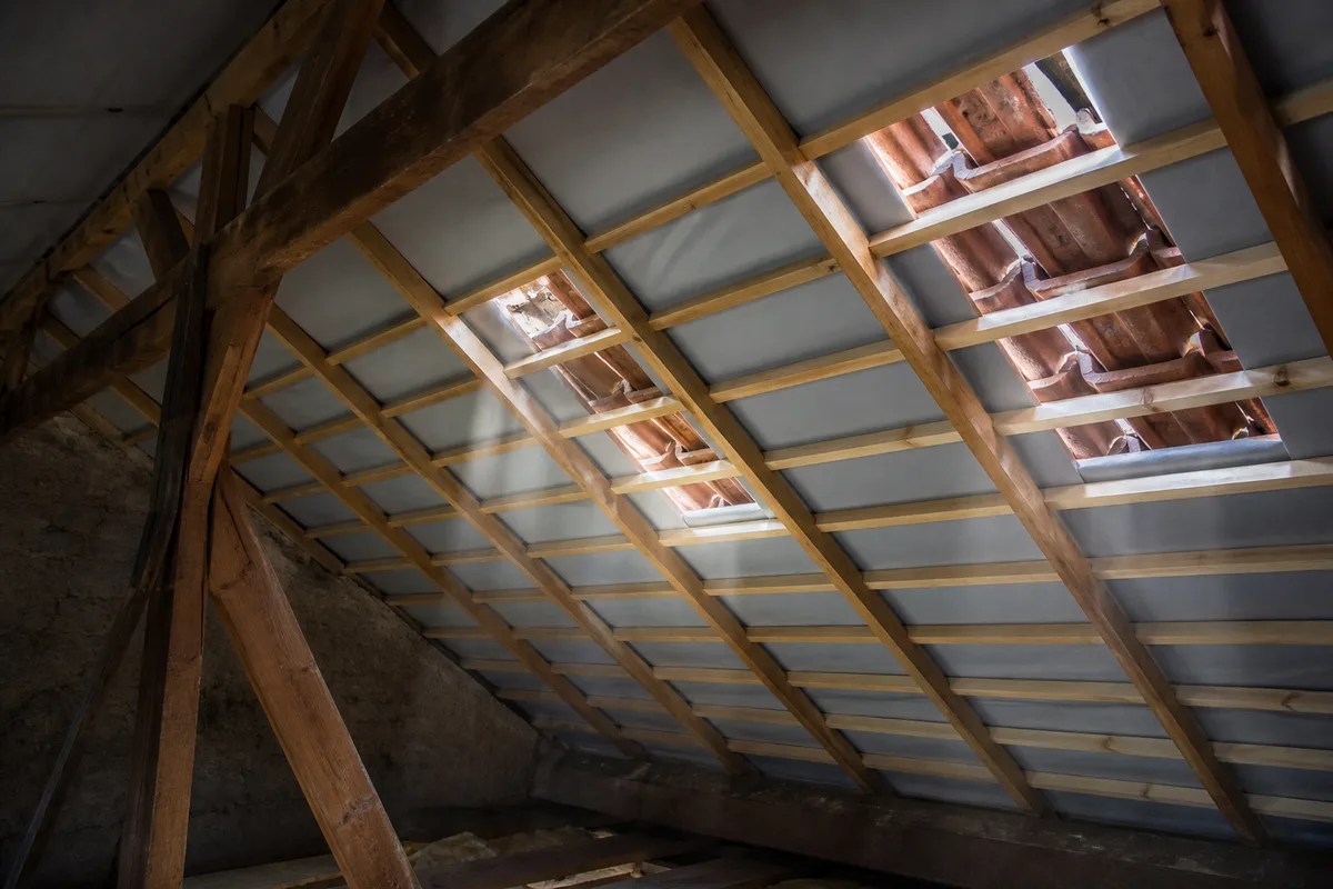 Écran de sous-toiture et liteaux apparents sur une charpente en cours de rénovation